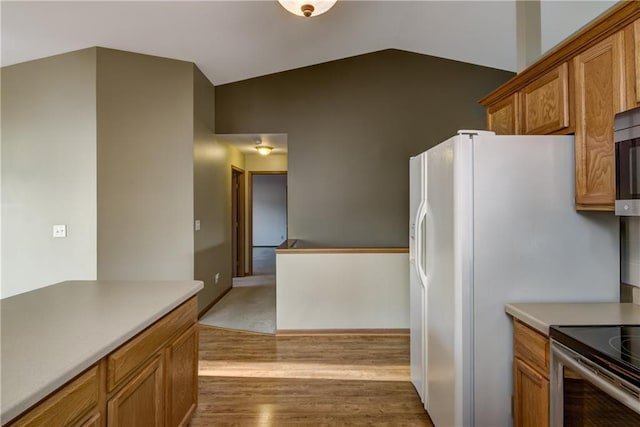 kitchen featuring lofted ceiling and light hardwood / wood-style flooring