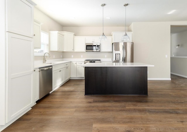 kitchen featuring a kitchen island, light countertops, dark wood-style floors, white cabinets, and stainless steel appliances