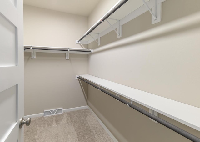 spacious closet featuring visible vents and light colored carpet