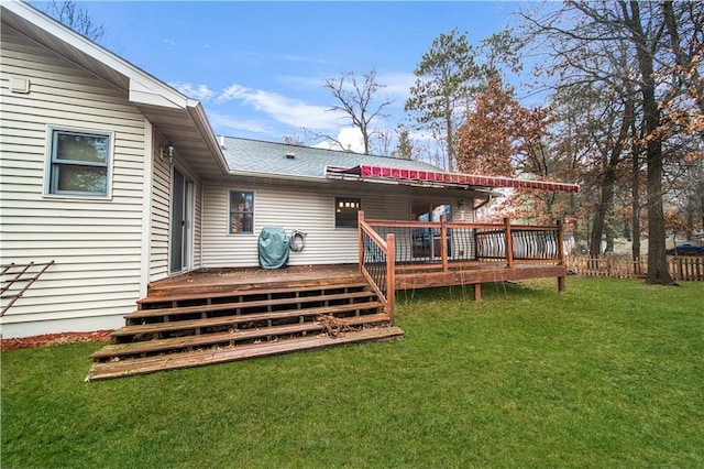 rear view of property featuring a yard and a deck