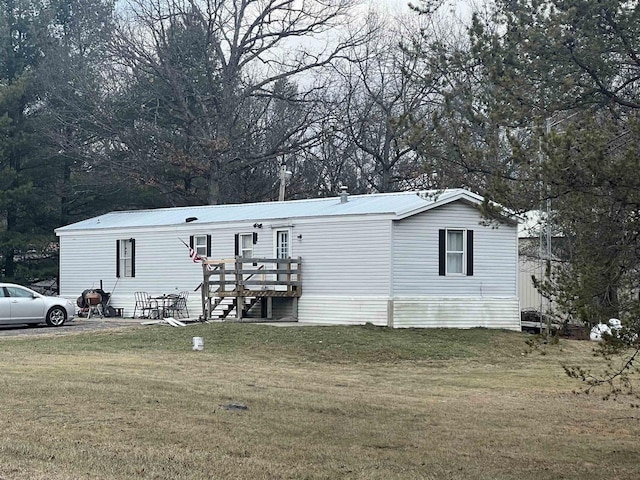 view of front of home featuring a wooden deck and a front lawn