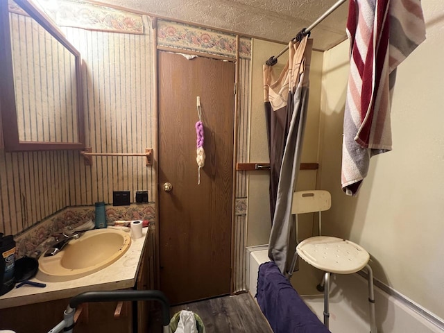 bathroom with hardwood / wood-style flooring, shower / bath combo, a textured ceiling, and vanity