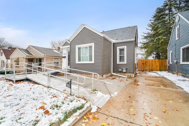 snow covered back of property featuring a wooden deck