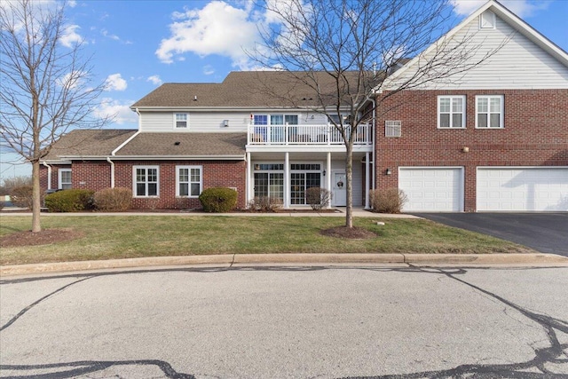 view of front of home featuring a balcony, a front lawn, and a garage