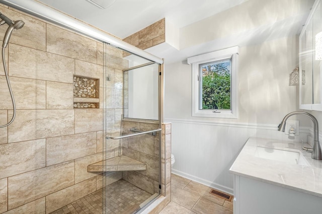 bathroom featuring tile patterned flooring, vanity, and a shower with shower door