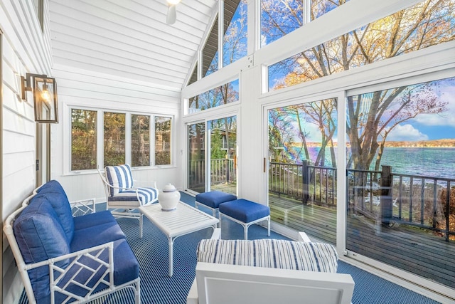 sunroom with a water view, vaulted ceiling, and ceiling fan