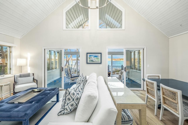 living room featuring hardwood / wood-style floors, high vaulted ceiling, a water view, and a wealth of natural light