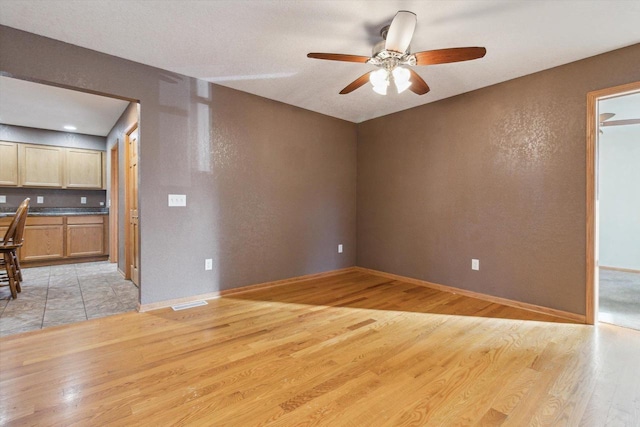 unfurnished room featuring ceiling fan and light wood-type flooring