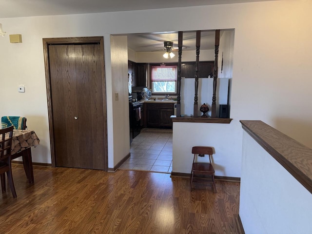 kitchen featuring dark wood-type flooring, ceiling fan, dark brown cabinets, white fridge, and range