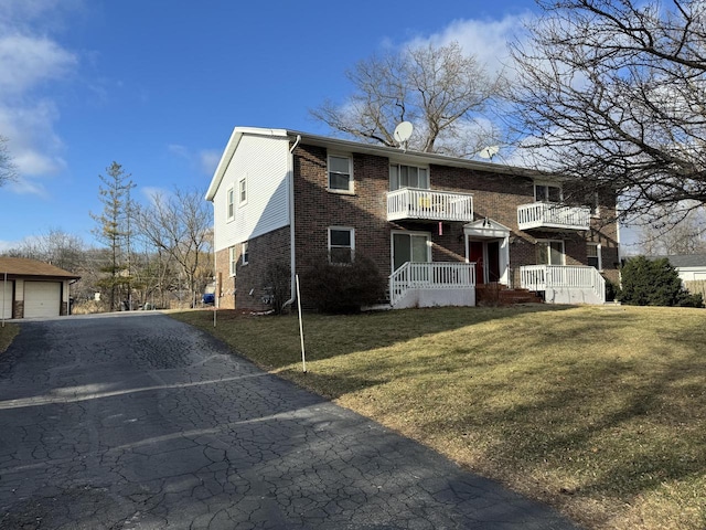 view of front of property featuring a balcony and a front yard