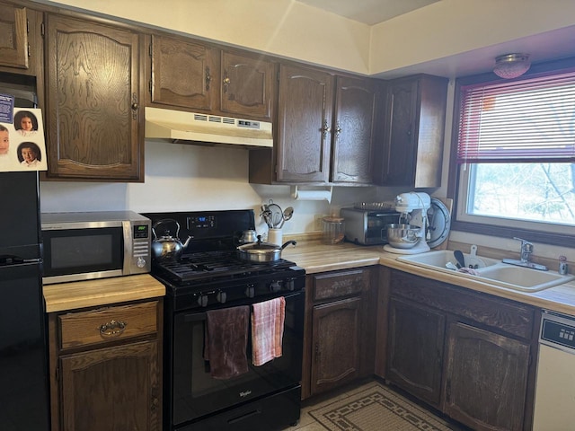 kitchen featuring black gas range oven, dark brown cabinetry, sink, dishwasher, and fridge