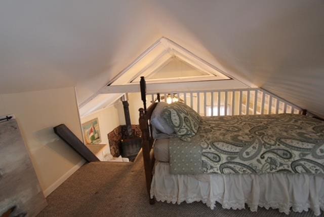 carpeted bedroom with lofted ceiling