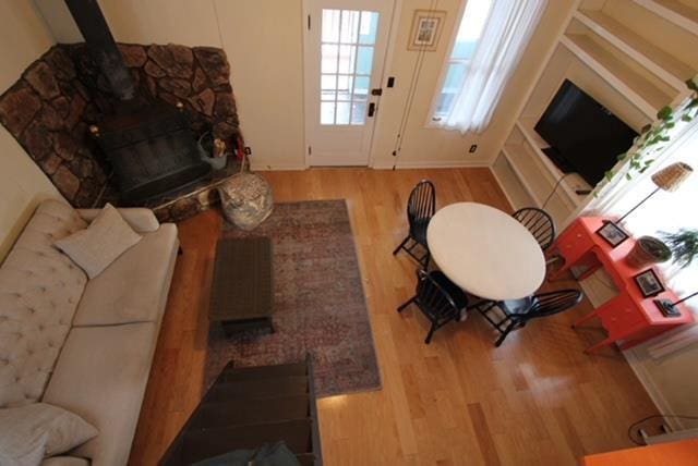 living room with a wood stove and light wood-type flooring