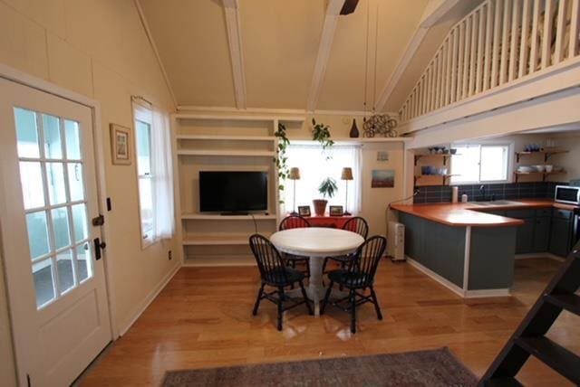 dining area featuring vaulted ceiling and hardwood / wood-style flooring