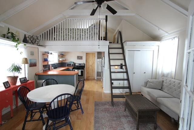 living room with hardwood / wood-style floors, ceiling fan, and lofted ceiling