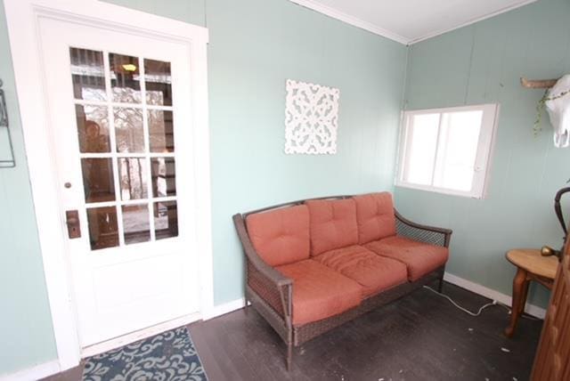 living area with dark hardwood / wood-style flooring and crown molding