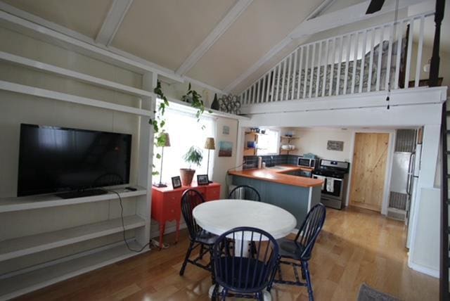 dining space featuring hardwood / wood-style flooring, ceiling fan, and lofted ceiling