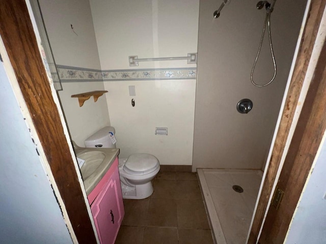 bathroom with tile patterned floors, vanity, toilet, and walk in shower