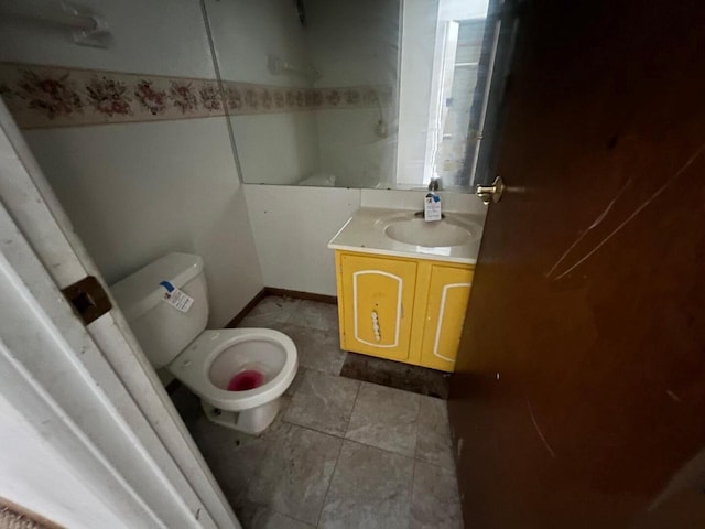 bathroom with toilet, vanity, and tile patterned floors