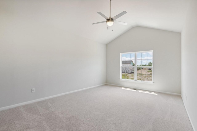 empty room featuring vaulted ceiling, light colored carpet, and ceiling fan