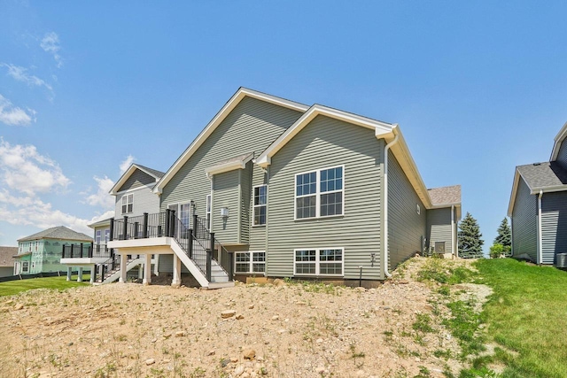 back of house featuring a wooden deck and a lawn