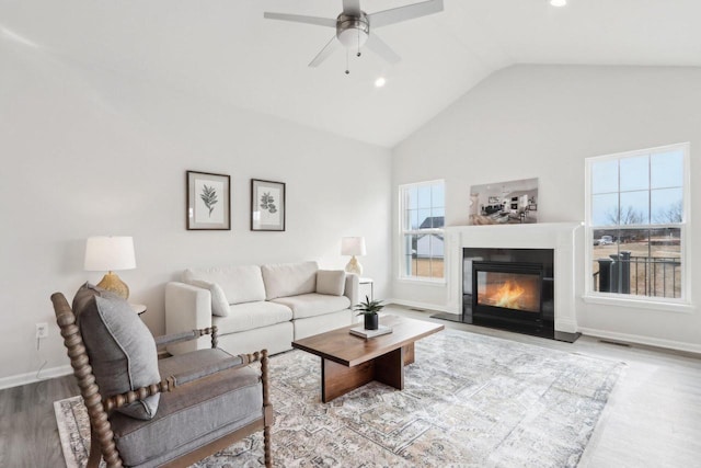 living room featuring vaulted ceiling, hardwood / wood-style floors, and ceiling fan