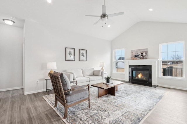 living room featuring hardwood / wood-style flooring, ceiling fan, and lofted ceiling