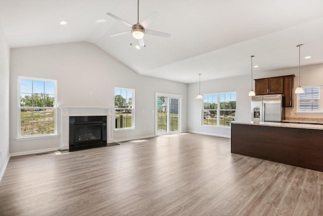 unfurnished living room featuring lofted ceiling, light hardwood / wood-style floors, and ceiling fan