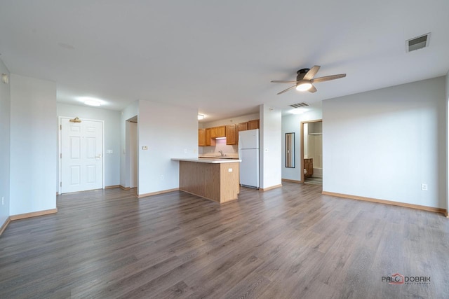 unfurnished living room featuring sink, hardwood / wood-style floors, and ceiling fan