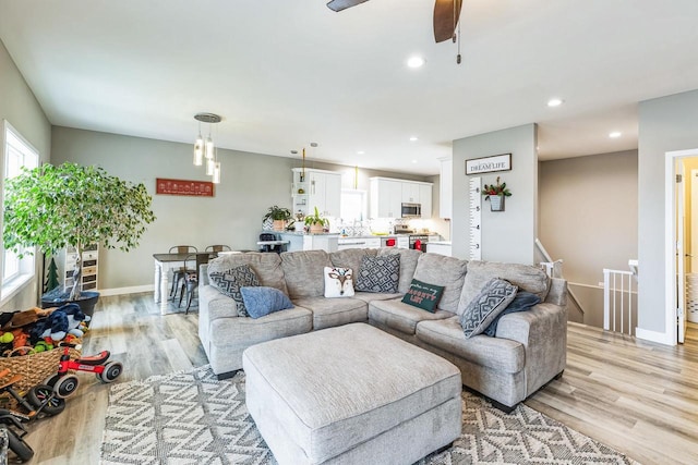 living room featuring light hardwood / wood-style floors and ceiling fan