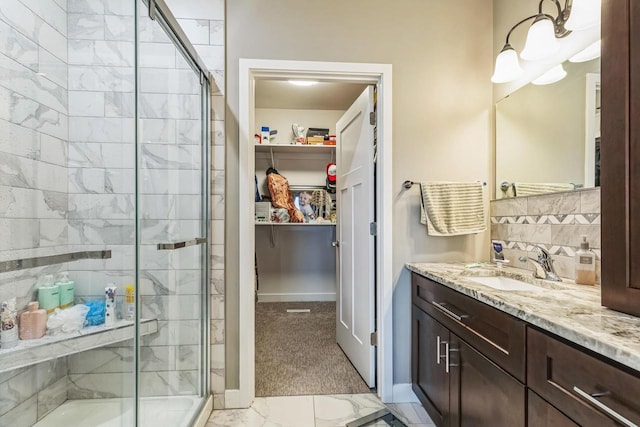 bathroom with vanity, an enclosed shower, and decorative backsplash