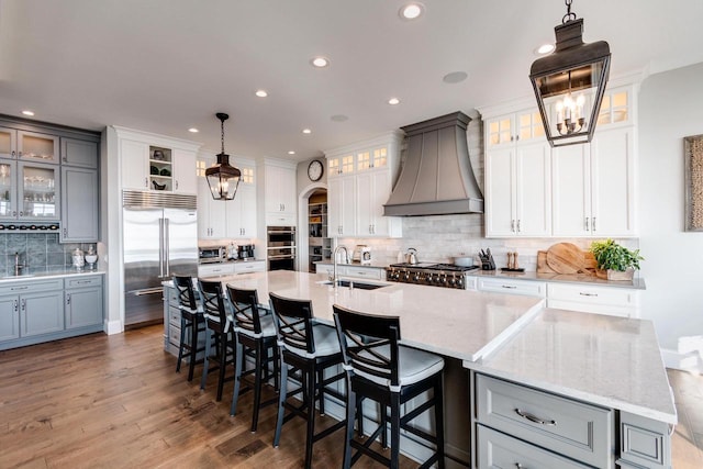 kitchen featuring a large island, custom range hood, and decorative light fixtures