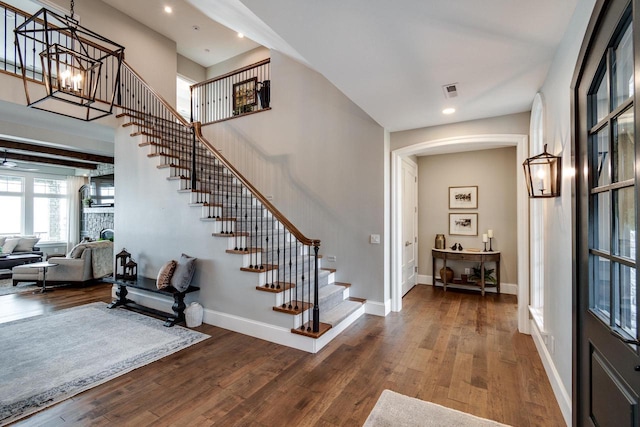 entrance foyer with a fireplace, hardwood / wood-style floors, and a chandelier