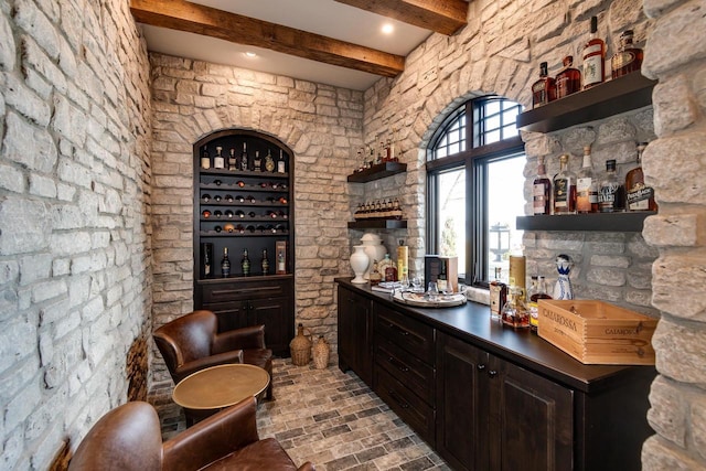 bar with beam ceiling and dark brown cabinetry