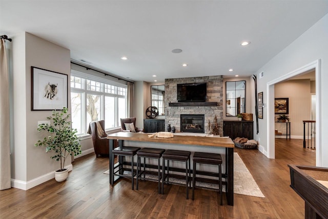 interior space with wood-type flooring and a stone fireplace