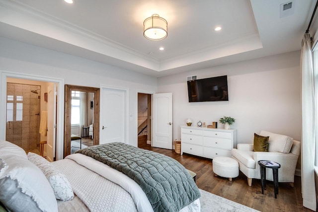 bedroom with dark hardwood / wood-style flooring, a raised ceiling, and crown molding