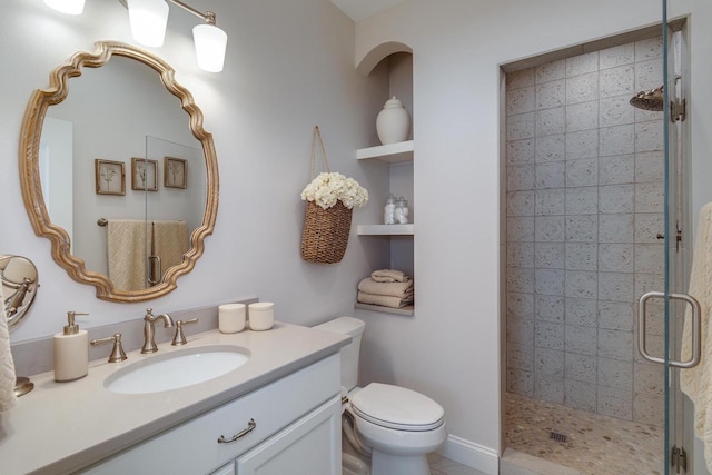 bathroom featuring vanity, toilet, and a shower with shower door