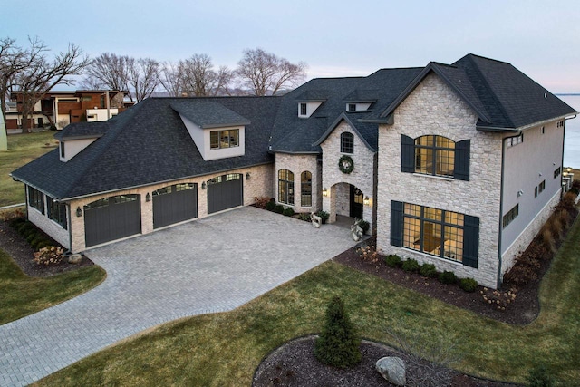 french country home featuring a lawn and a garage