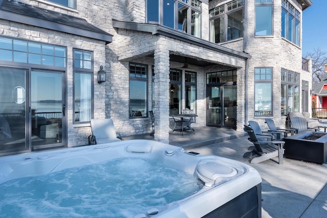 view of patio / terrace featuring a fire pit and a hot tub