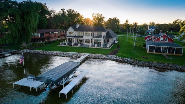 exterior space featuring a lawn, a balcony, and a water view