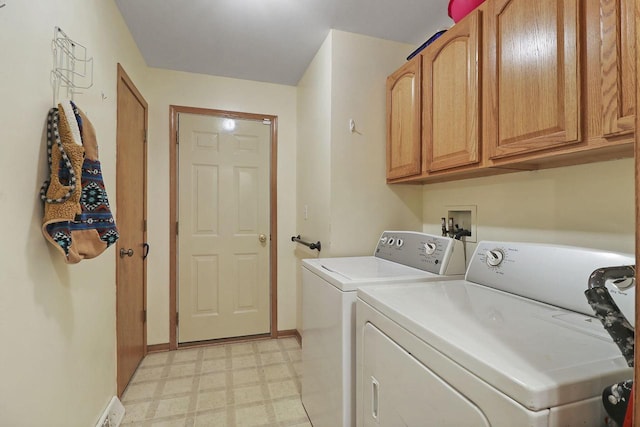 clothes washing area featuring cabinets and washing machine and clothes dryer