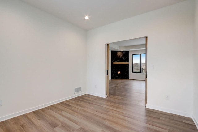 spare room with light hardwood / wood-style flooring and a fireplace