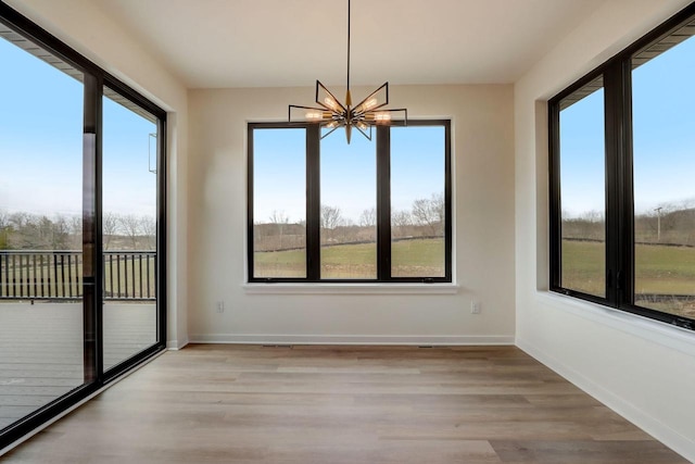 unfurnished sunroom with plenty of natural light and a chandelier