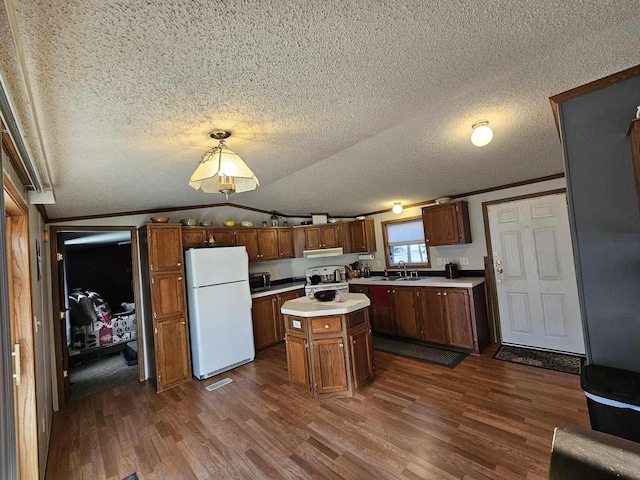 kitchen with a center island, lofted ceiling, dark wood-type flooring, sink, and stainless steel appliances