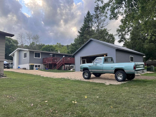 view of side of home with a yard, a deck, a garage, and an outdoor structure