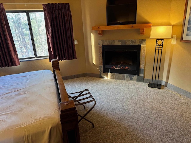 carpeted bedroom featuring a tile fireplace