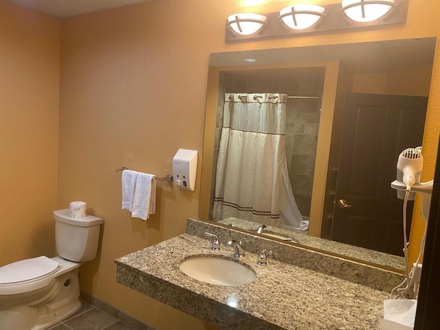 bathroom featuring toilet, a shower with curtain, tile patterned floors, and sink