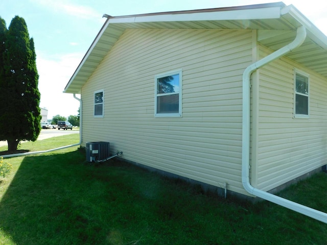 view of property exterior featuring central air condition unit and a yard