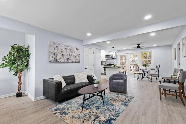 living room with ceiling fan and light hardwood / wood-style floors