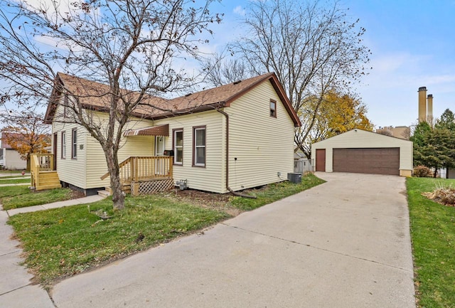 view of front of home featuring a front yard, a garage, an outdoor structure, and central air condition unit